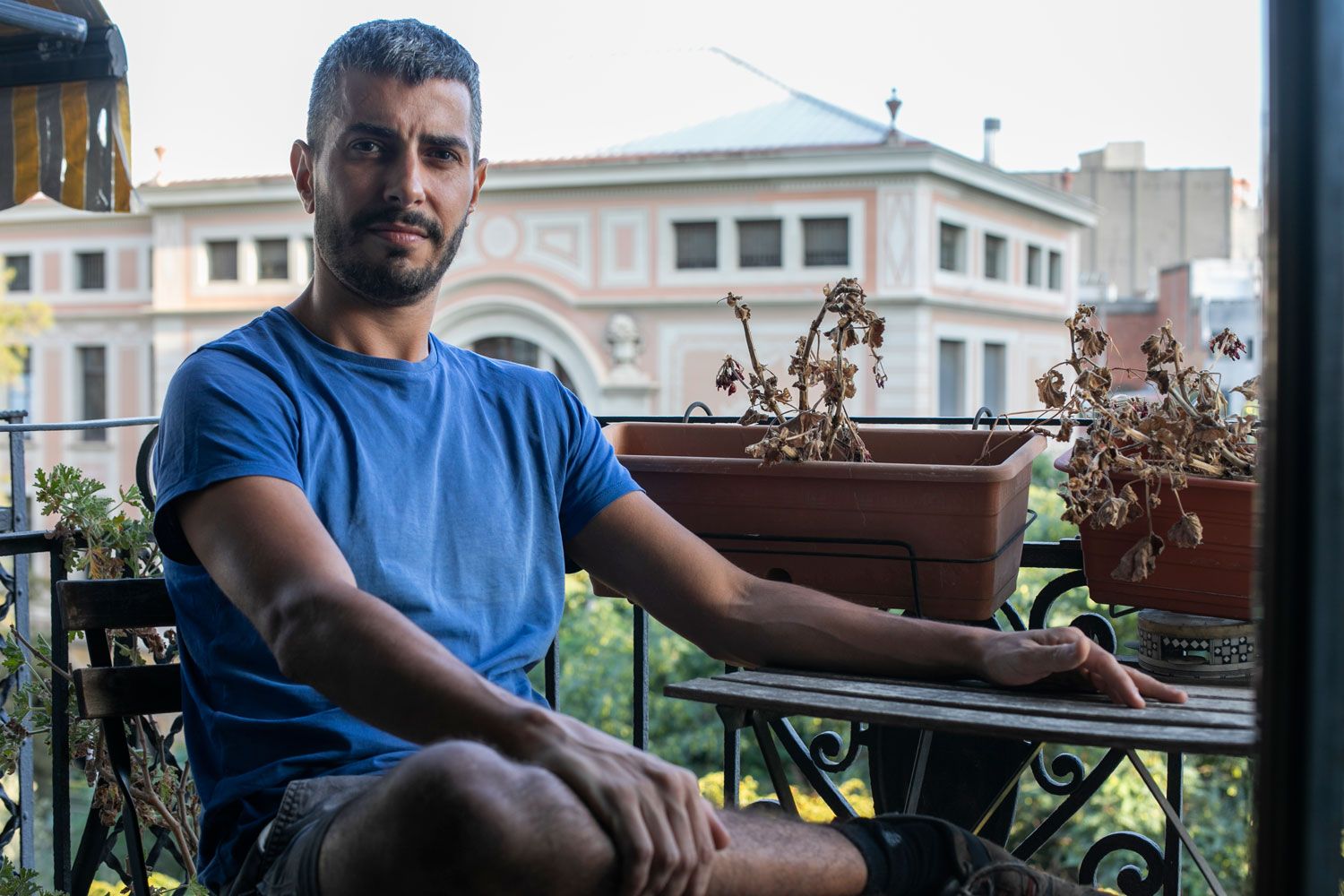 Noi assegut en una cadira al seu balcó